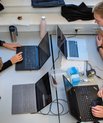 [Translate to English:] Fire mennesker sidder med hver deres computer om et bord